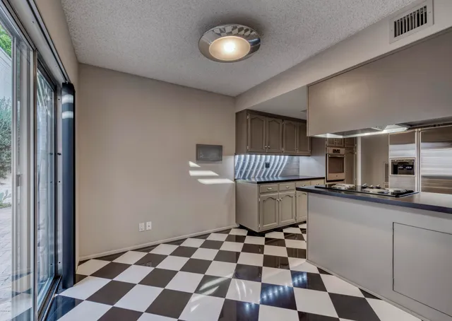 a kitchen with a checkered floor and a stove top oven