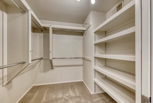 a view of walk in closet with empty racks