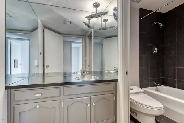 a bathroom with a sink a toilet a mirror and shower