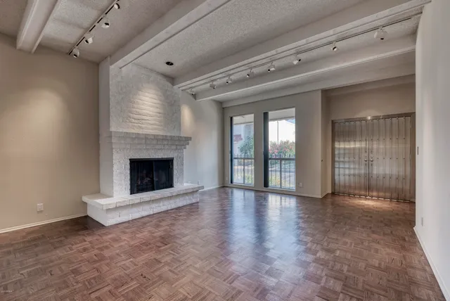 a view of an empty room with a fireplace and a window
