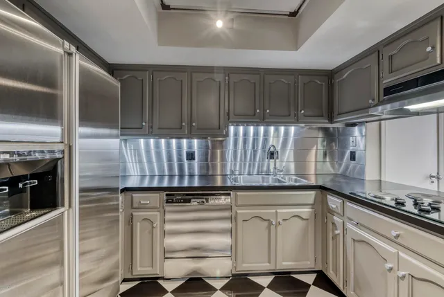 a kitchen with white cabinets and appliances