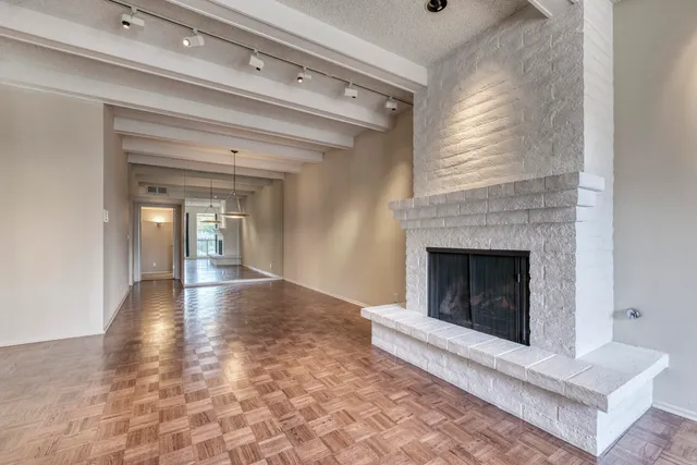 a view of a livingroom with wooden floor and a fireplace