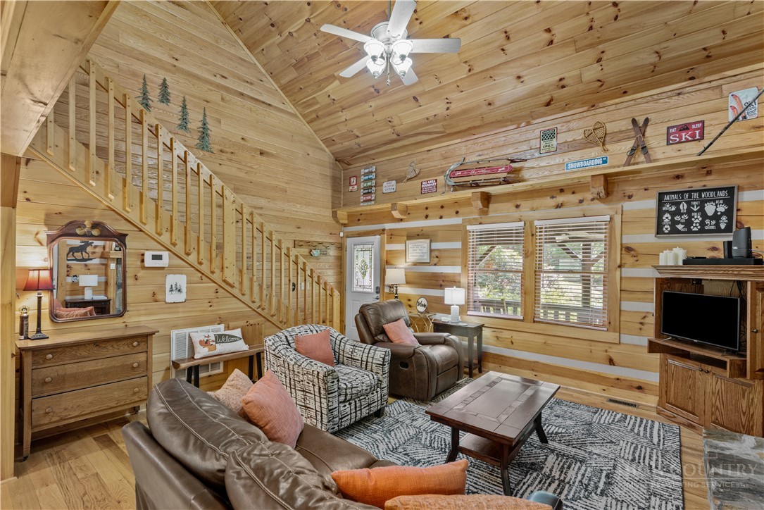 339 Welcome Way Boone, NC 28607 - Photo 5 of 20 a living room with furniture a flat screen tv and a floor to ceiling window