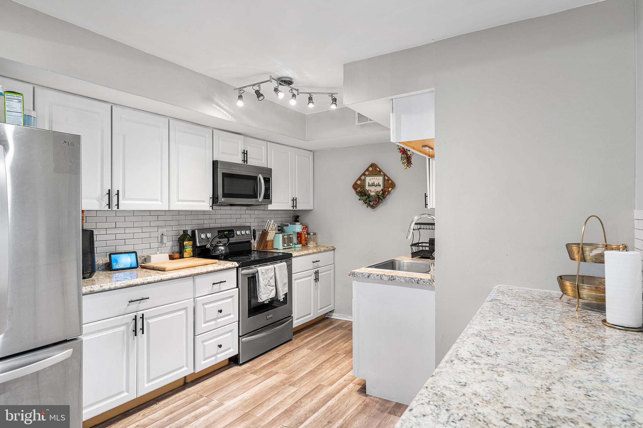 115 East Kings Highway, Unit 186 Maple Shade, NJ 08052 - Photo 9 of 25 a kitchen with granite countertop white cabinets and white appliances