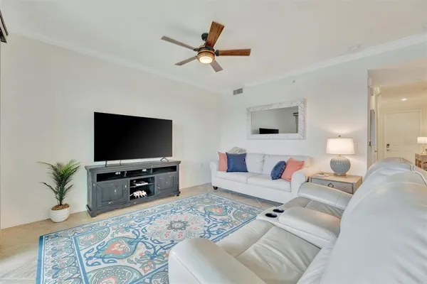 a living room with furniture ceiling fan and a rug
