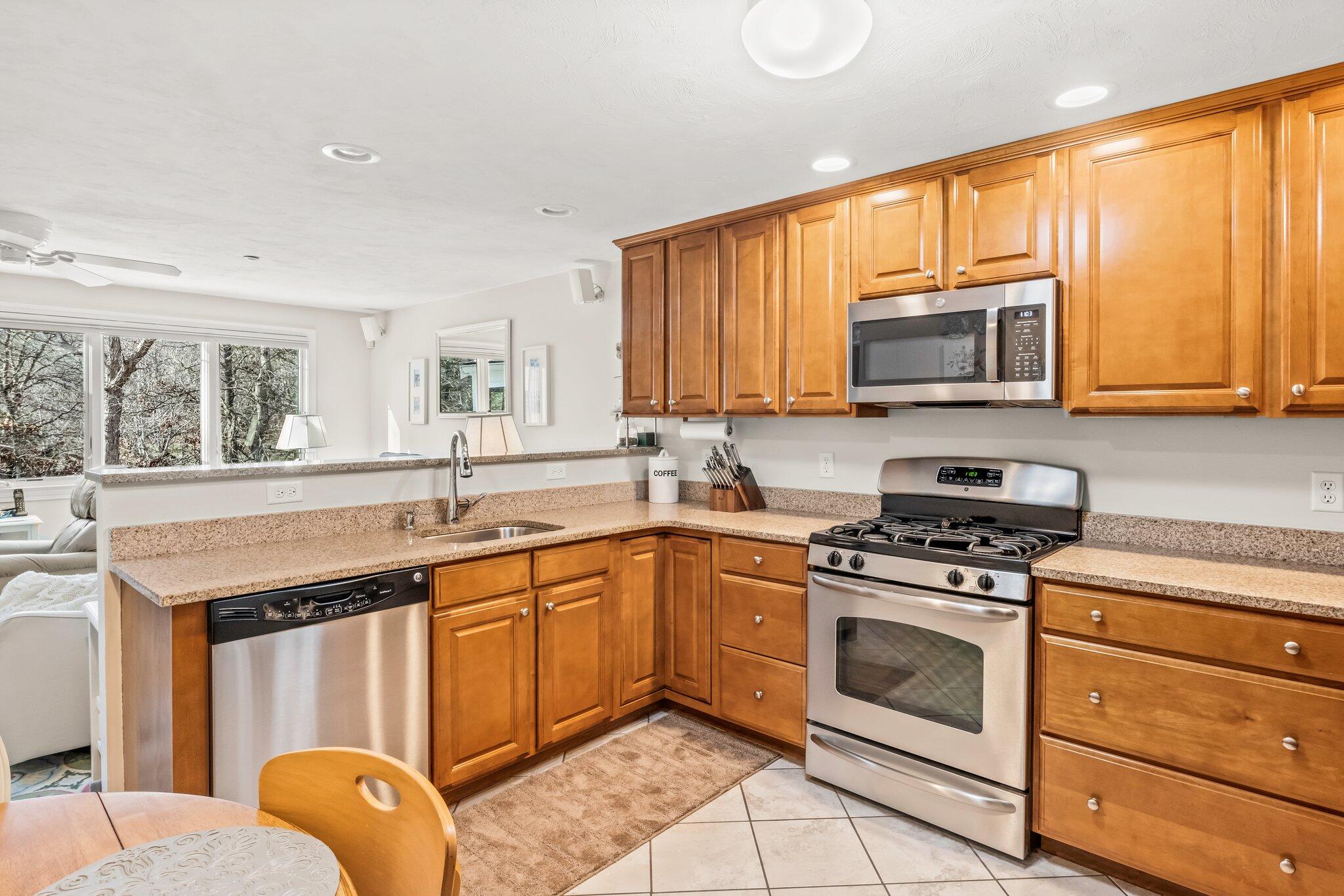 22 North Ridge Road Mashpee, MA 02649 - Photo 4 of 33 a kitchen with stainless steel appliances granite countertop wooden cabinets stove a sink and dishwasher with a large window