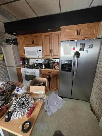 a kitchen with stainless steel appliances granite countertop a sink refrigerator and chairs
