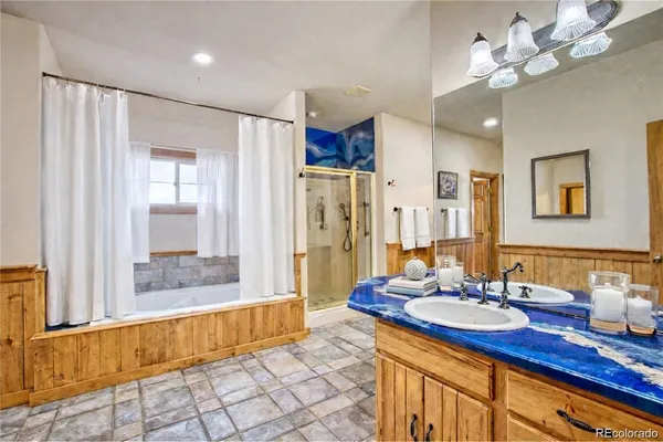 a bathroom with a granite countertop sink a large mirror and a shower