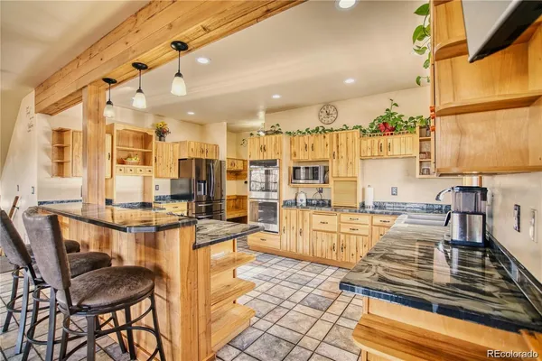 a kitchen with stainless steel appliances kitchen island granite countertop a table and chairs in it