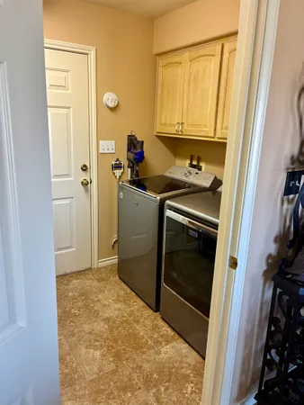 a bathroom with a granite countertop sink and a washing machine