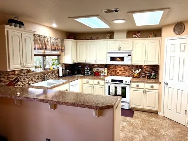 a kitchen with stainless steel appliances granite countertop a stove a sink and a microwave
