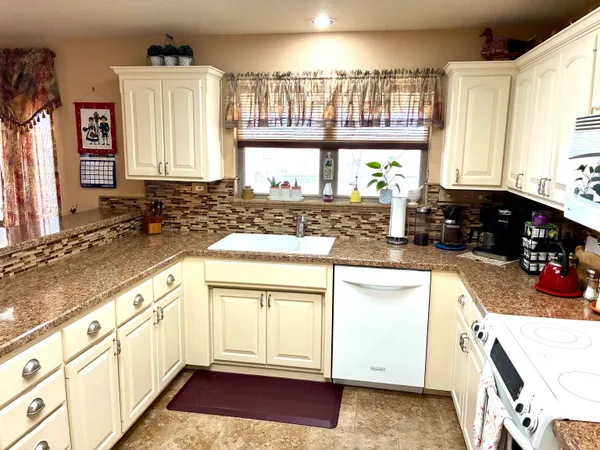 a kitchen with a large window appliances and cabinets