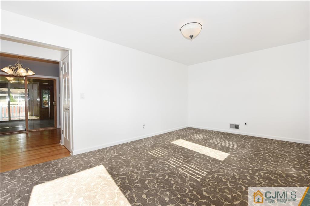 214 3rd Street Middlesex, NJ 08846 - Photo 3 of 22 a view of a room with wooden floor and white walls