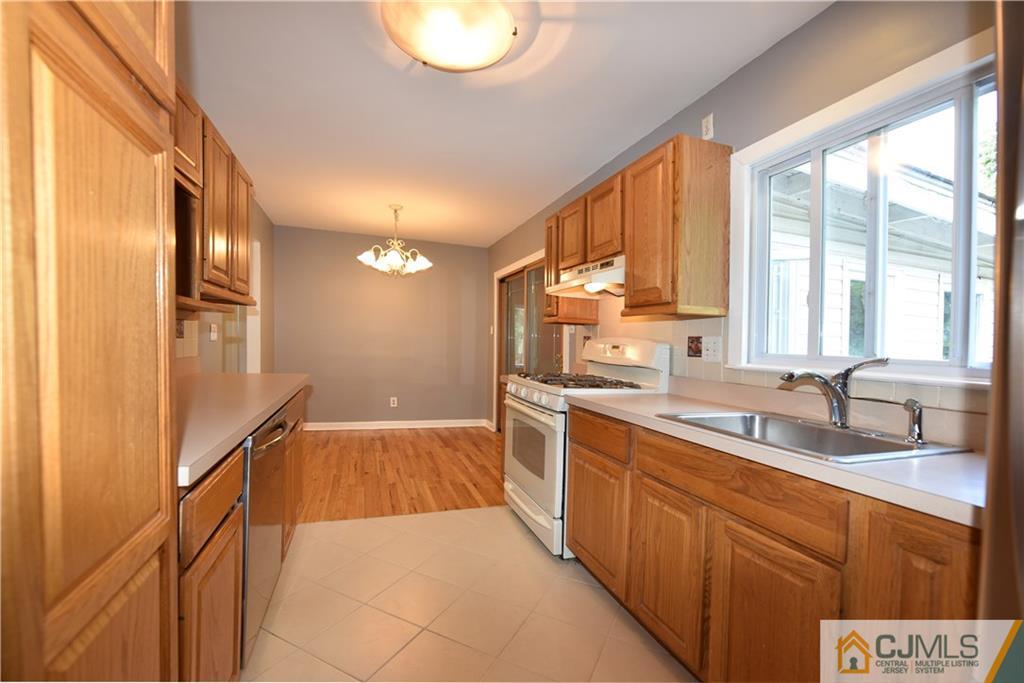 214 3rd Street Middlesex, NJ 08846 - Photo 6 of 22 a large kitchen with kitchen island a large window a sink and stainless steel appliances