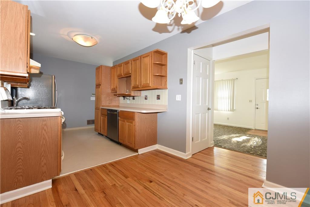 214 3rd Street Middlesex, NJ 08846 - Photo 7 of 22 a kitchen with kitchen island stainless steel appliances a sink cabinets and wooden floor