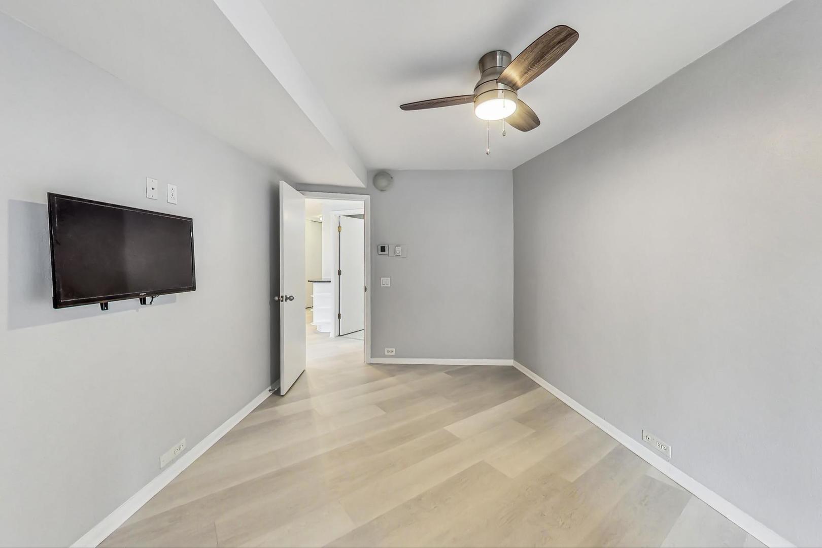 300 North State Street, Unit 4308 Chicago, IL 60654 - Photo 13 of 32 a view of a livingroom with a flat screen tv and a ceiling fan