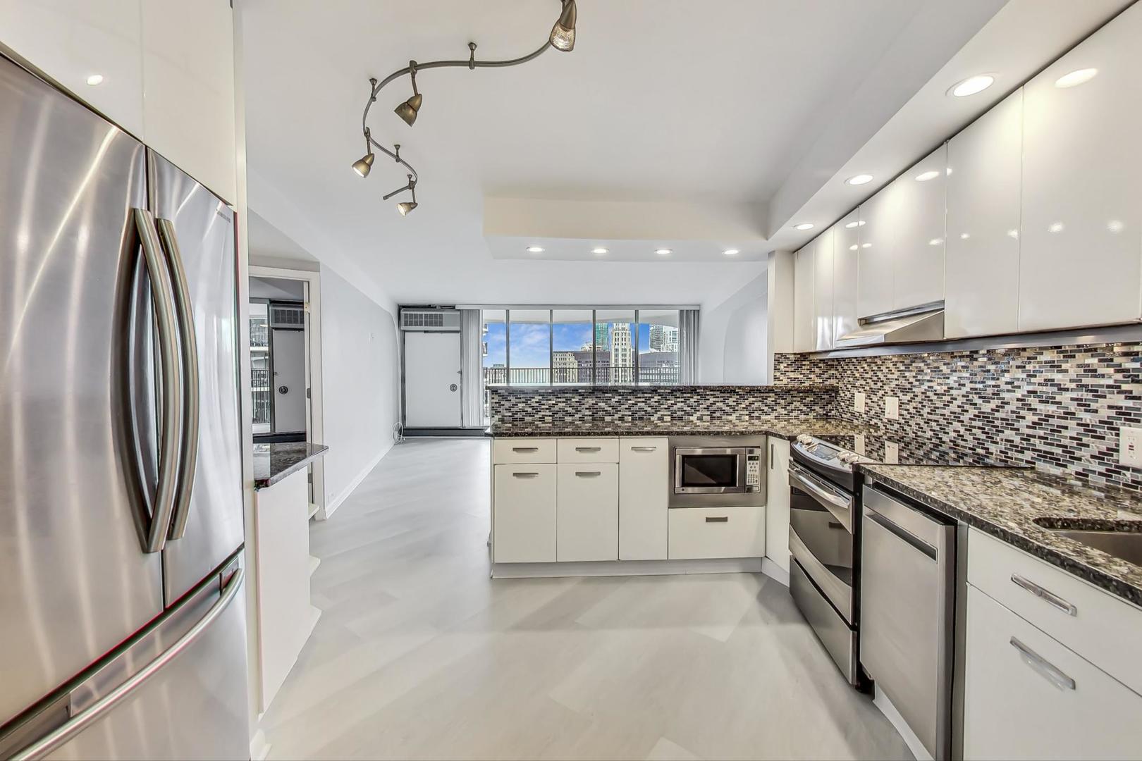 300 North State Street, Unit 4308 Chicago, IL 60654 - Photo 8 of 32 a kitchen with stainless steel appliances granite countertop a refrigerator and a stove top oven