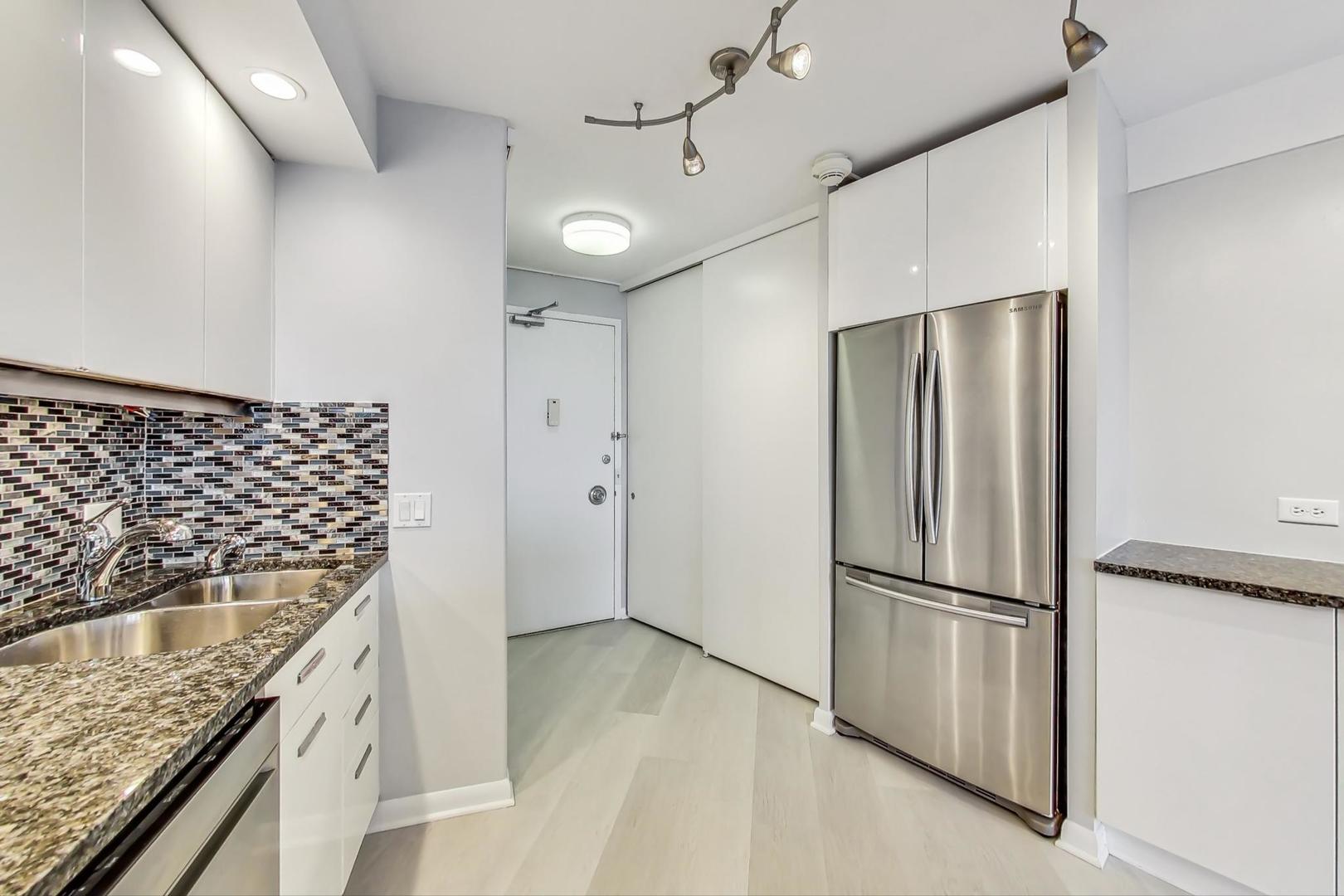 300 North State Street, Unit 4308 Chicago, IL 60654 - Photo 10 of 32 a kitchen with granite countertop a refrigerator and a sink