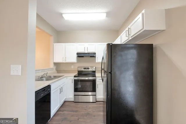 a kitchen with stainless steel appliances a refrigerator a sink a stove a microwave a counter space and cabinets