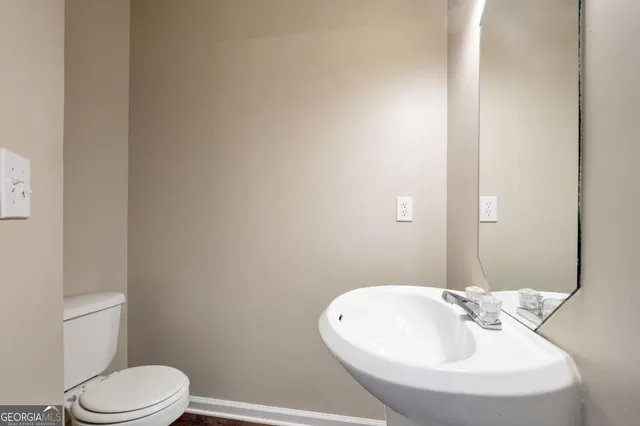 a bathroom with a sink a toilet and mirror