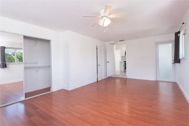 a view of empty room with wooden floor