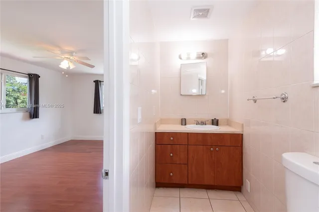 a bathroom with a toilet a sink a mirror and vanity