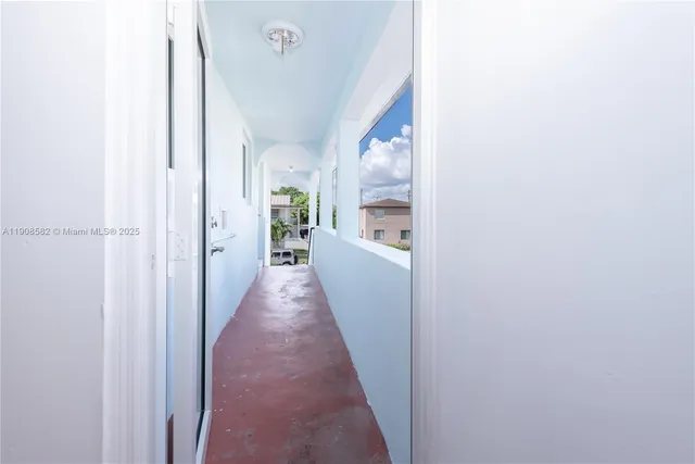 a view of a hallway with a white walls and stairs
