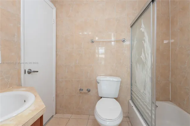 a white toilet sitting next to a bathroom sink
