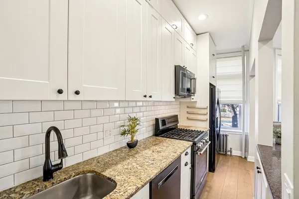 a kitchen with stainless steel appliances granite countertop a sink stove and refrigerator