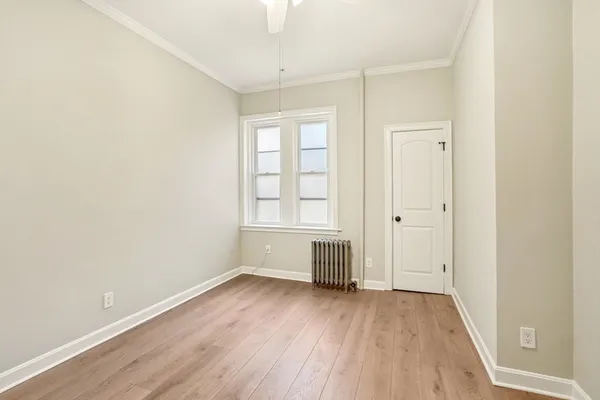 an empty room with wooden floor and window