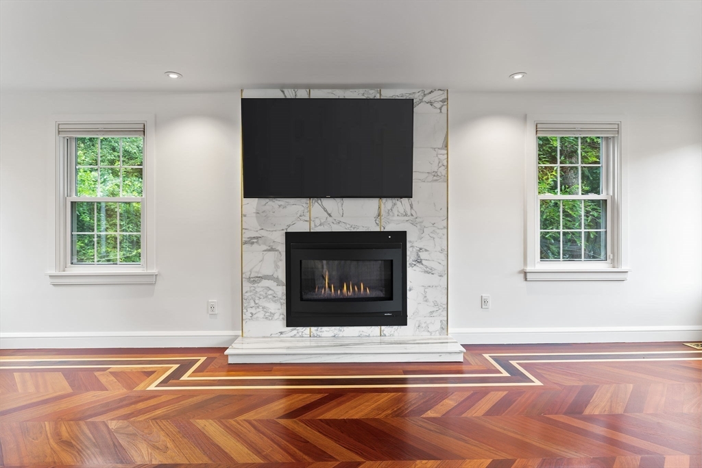 4 Hadley Road Lexington, MA 02420 - Photo 12 of 35 a living room with a fireplace and a flat screen tv