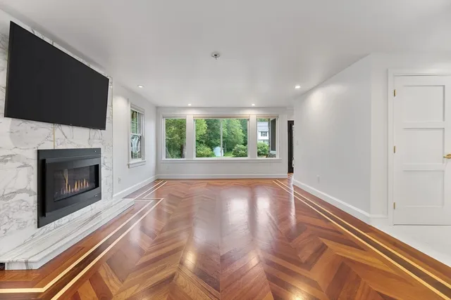 a view of an empty room with a fireplace and a window