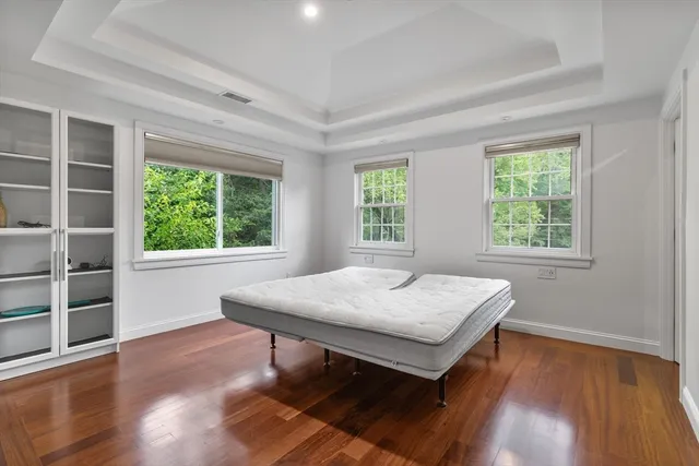 a bedroom with a bed a table and wooden floor