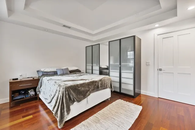 a bedroom with a bed and wooden floor