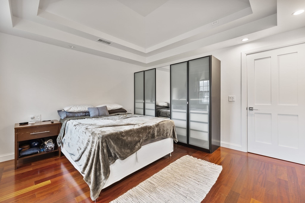 4 Hadley Road Lexington, MA 02420 - Photo 15 of 35 a bedroom with a bed a table and wooden floor