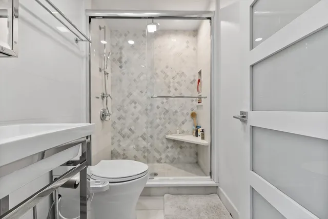 a bathroom with a shower a toilet and sink