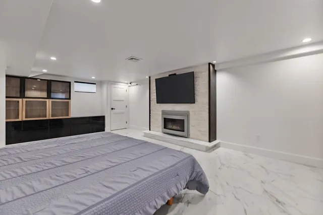 a large bedroom with a bed and a flat screen tv