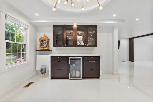a living room with stainless steel appliances kitchen island a cabinets and a fireplace
