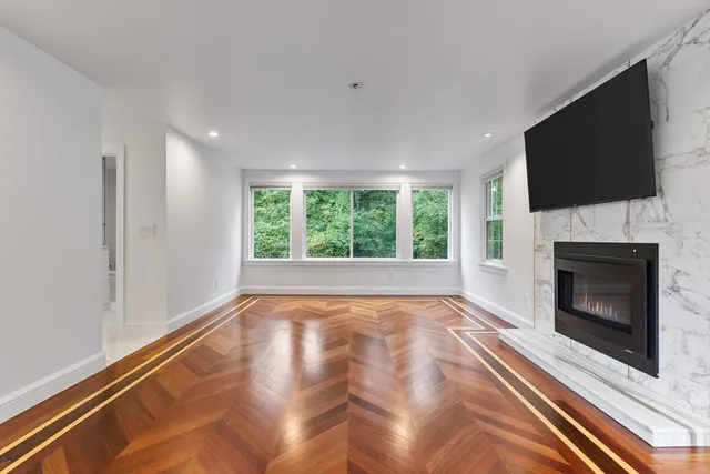 a view of an empty room with a fireplace and a window