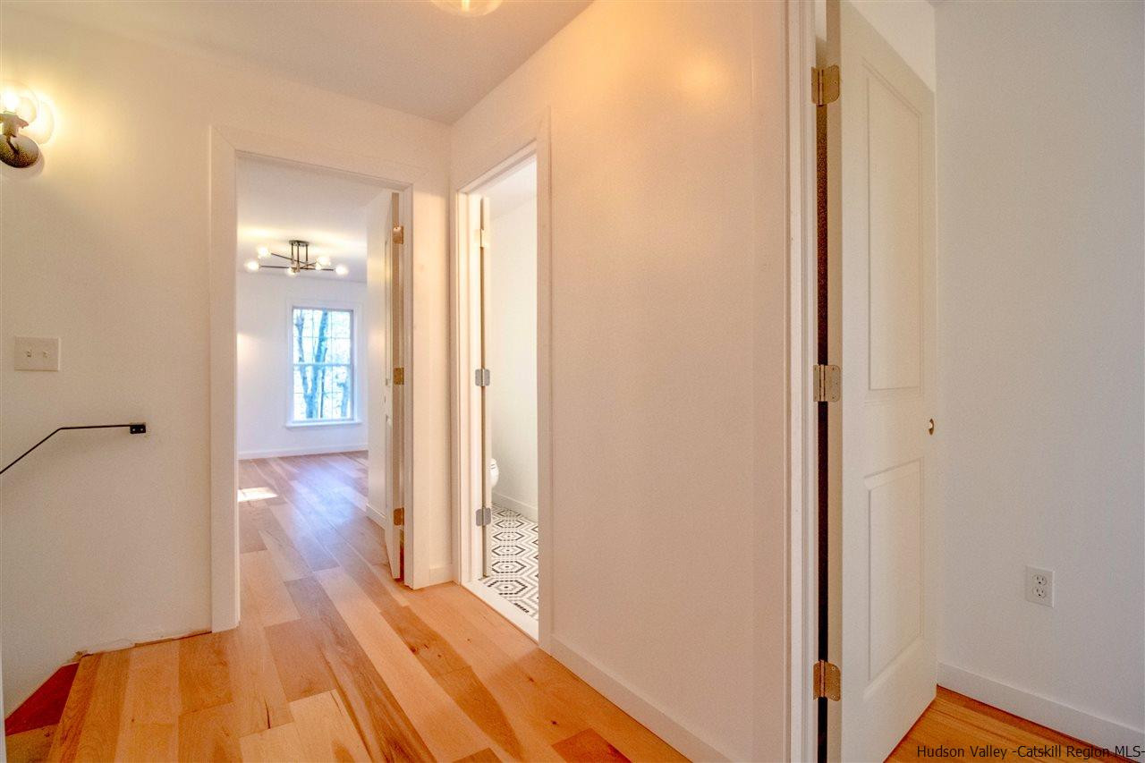 25 Laurel Hollow Road Kerhonkson, NY 12446 - Photo 16 of 30 a view of a hallway with wooden floor and a bathroom