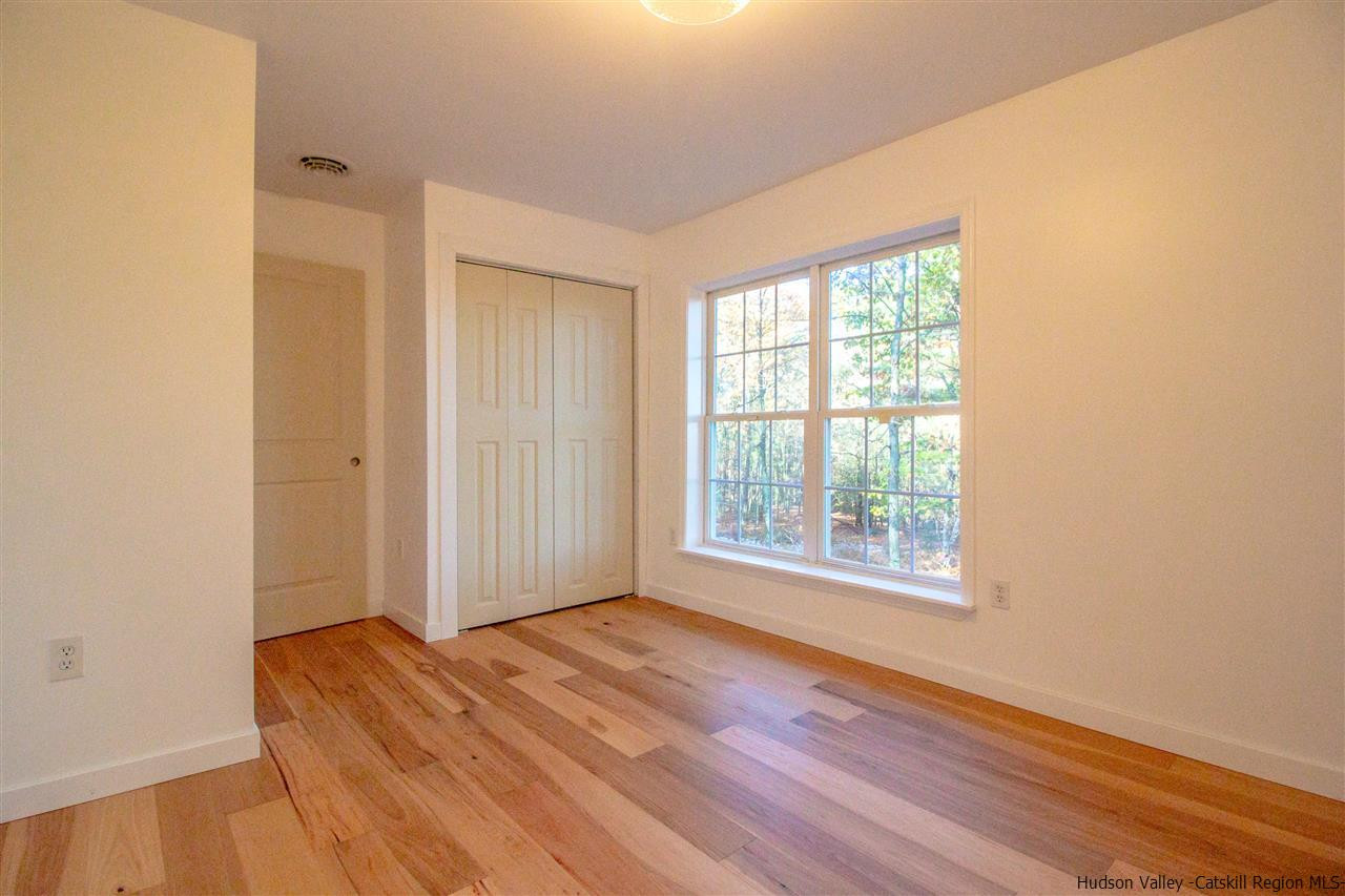 25 Laurel Hollow Road Kerhonkson, NY 12446 - Photo 23 of 30 an empty room with wooden floor and windows