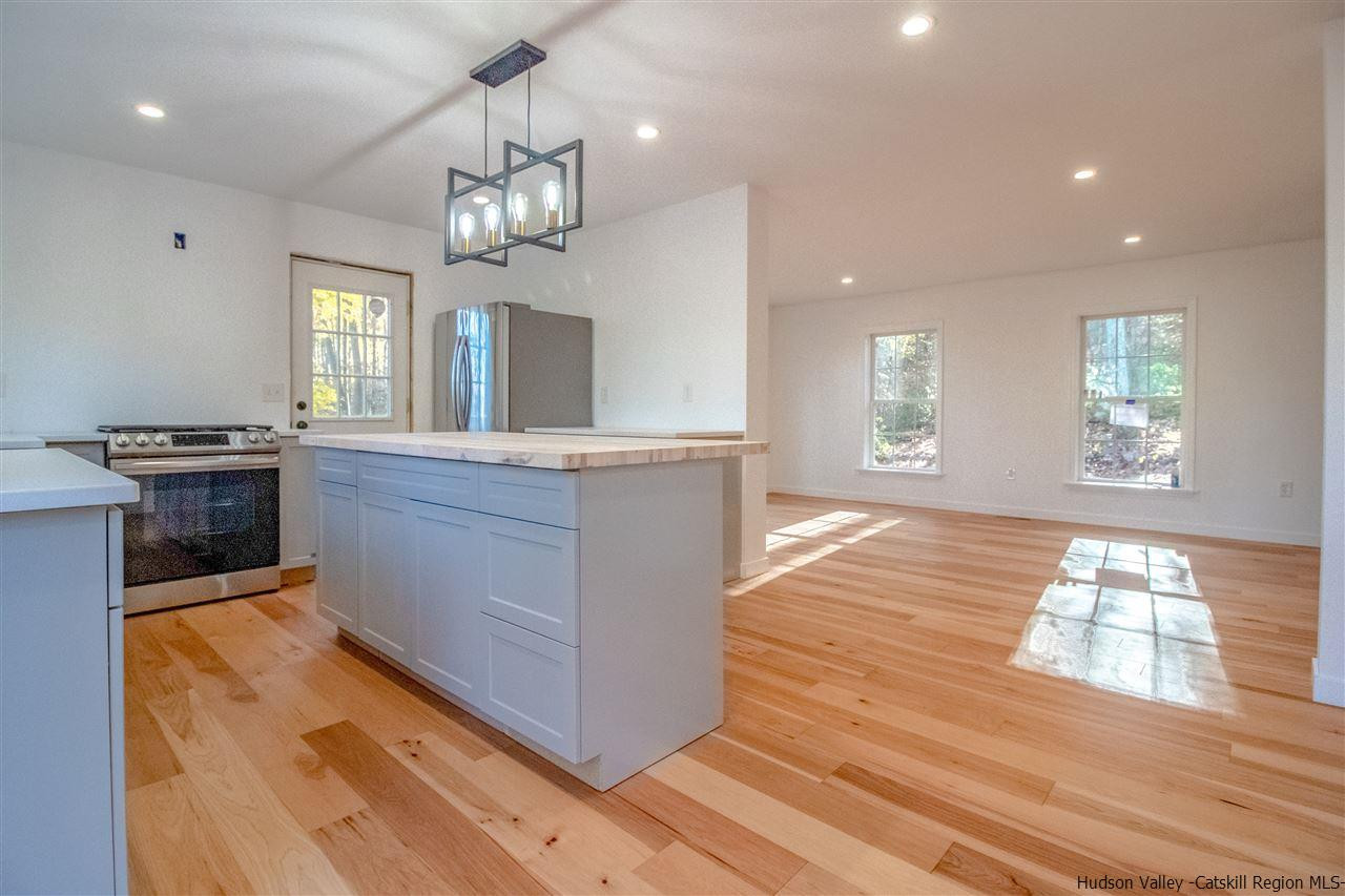 25 Laurel Hollow Road Kerhonkson, NY 12446 - Photo 6 of 30 a kitchen with kitchen island granite countertop wooden cabinets and a chandelier