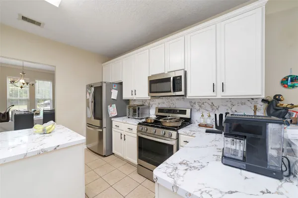 a kitchen with granite countertop a stove a sink and a refrigerator