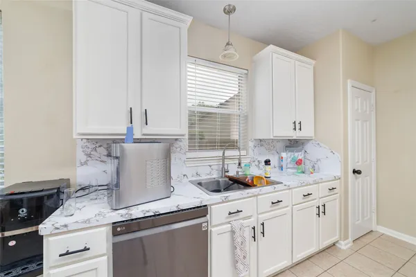 a kitchen with stainless steel appliances white cabinets and a window