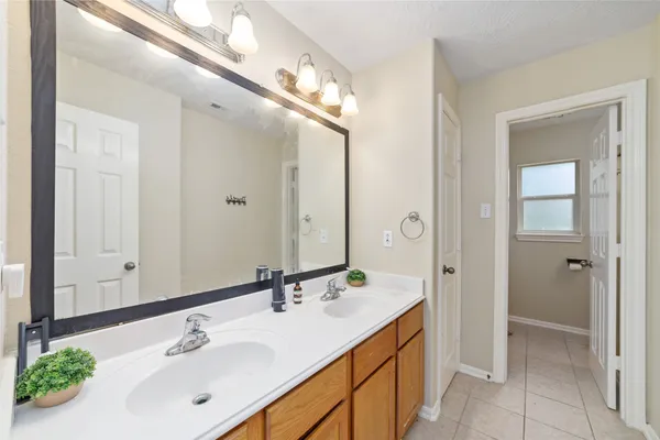 a bathroom with a double vanity sink mirror and shower