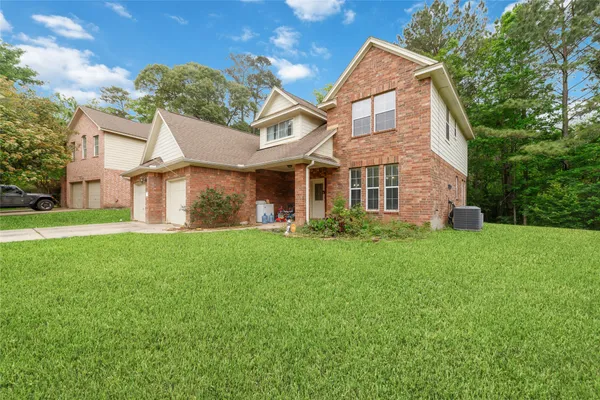 a front view of a house with a yard and trees