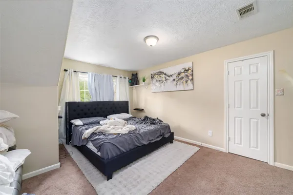 a bedroom with a bed and a window