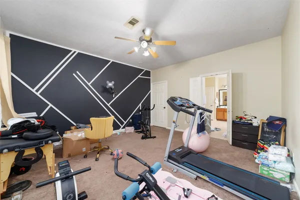 a room with gym equipment and wooden floor