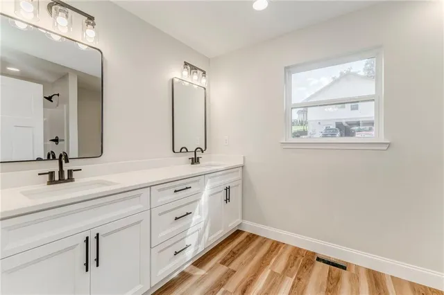 a view of a room with kitchen island stainless steel appliances wooden floor and windows