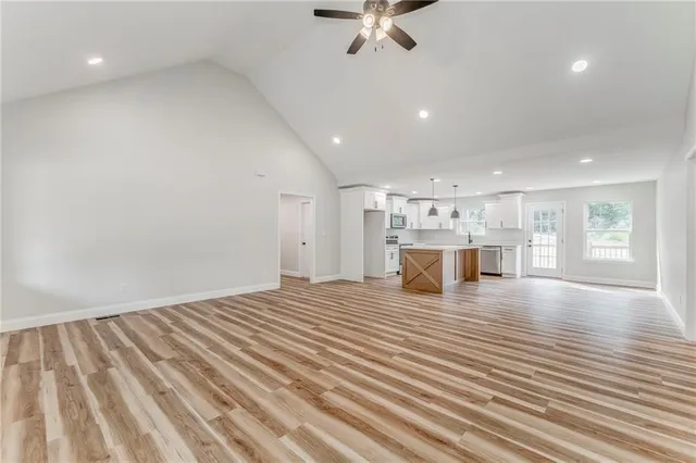 a kitchen with stainless steel appliances granite countertop a sink a stove a refrigerator and white cabinets